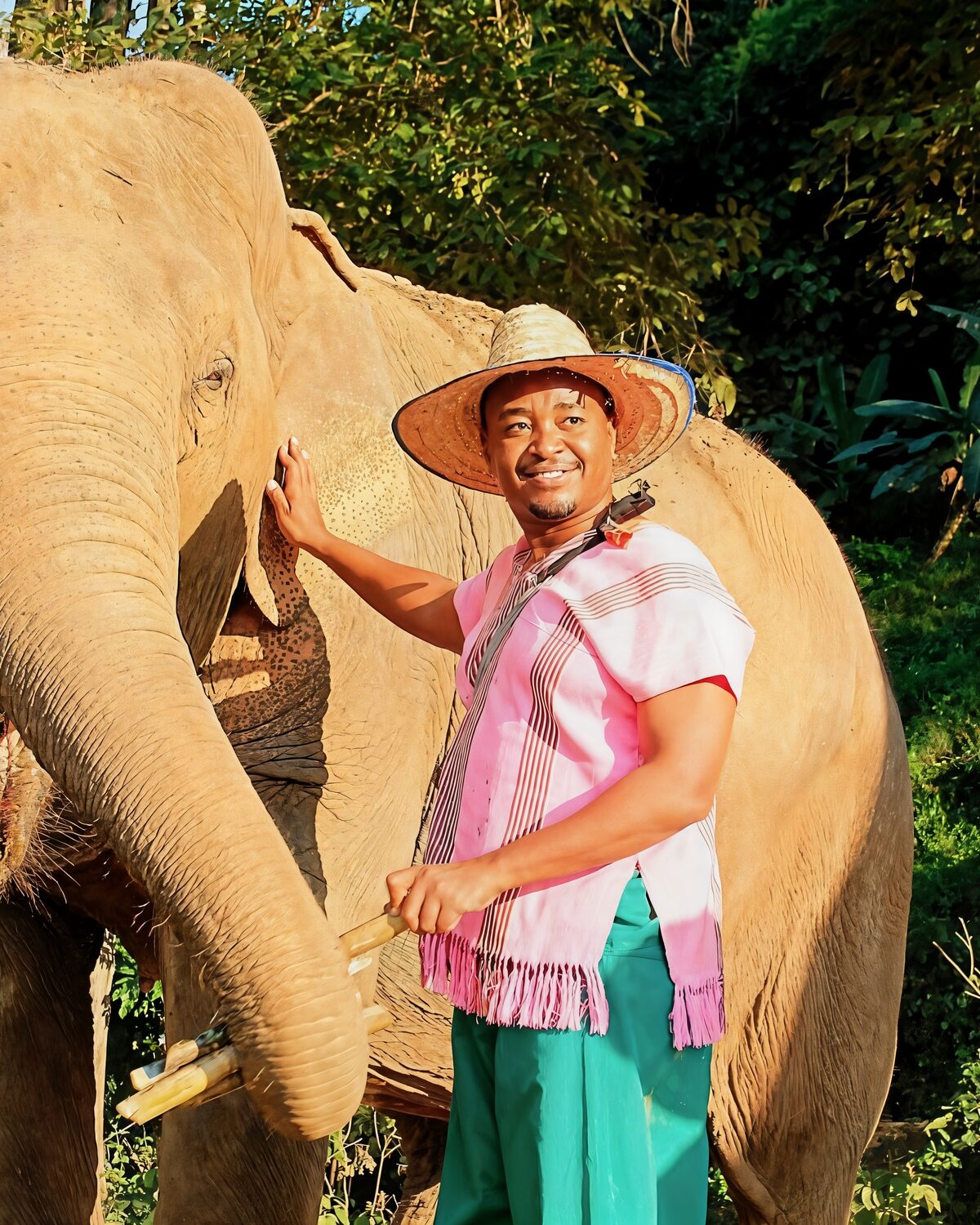 David Cameron Gikandi smiling beside an elephant in northern Thailand